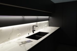 Modern,Kitchen,With,Black,Furniture,,White,Marble,Worktop,And,Backsplash.black