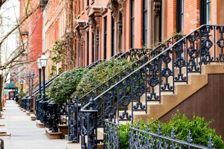 Row,Of,Old,Brownstone,Buildings,Along,An,Empty,Sidewalk,Block